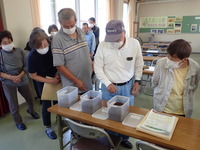 家畜ふん堆肥のサンプルを確認するユズ生産者